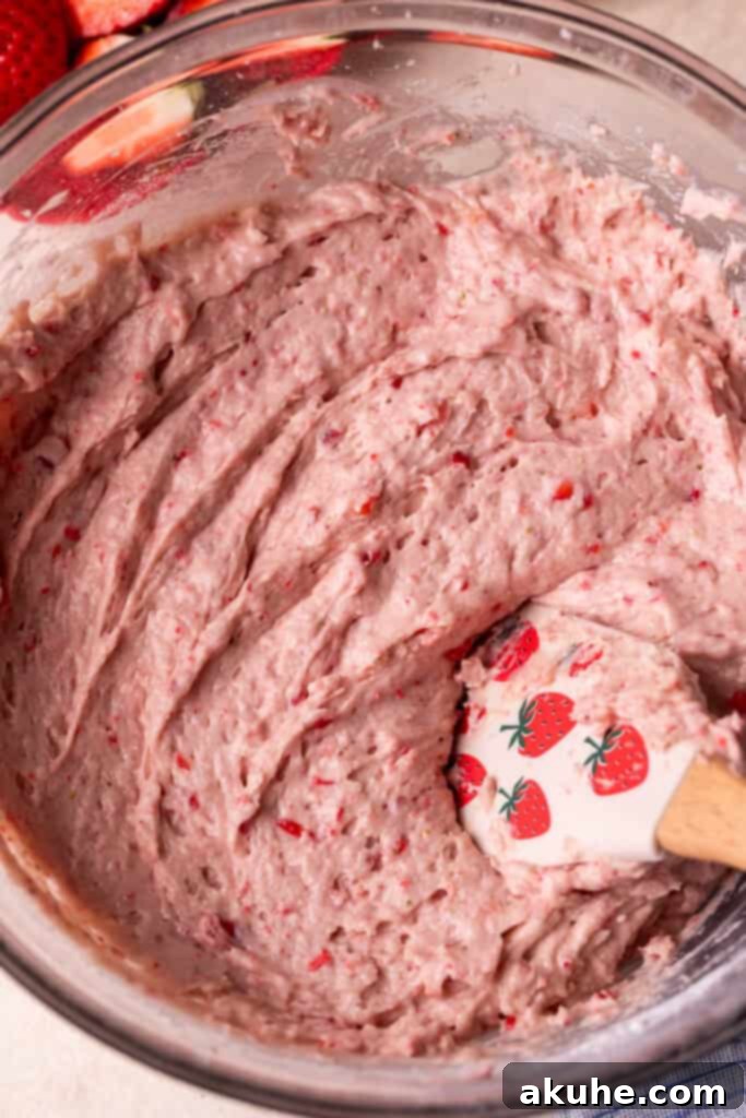 Perfect Fresh Strawberry Cake 5 Strawberry cake batter in a bowl, showcasing its distinct pink color after the freeze-dried strawberries have been incorporated.