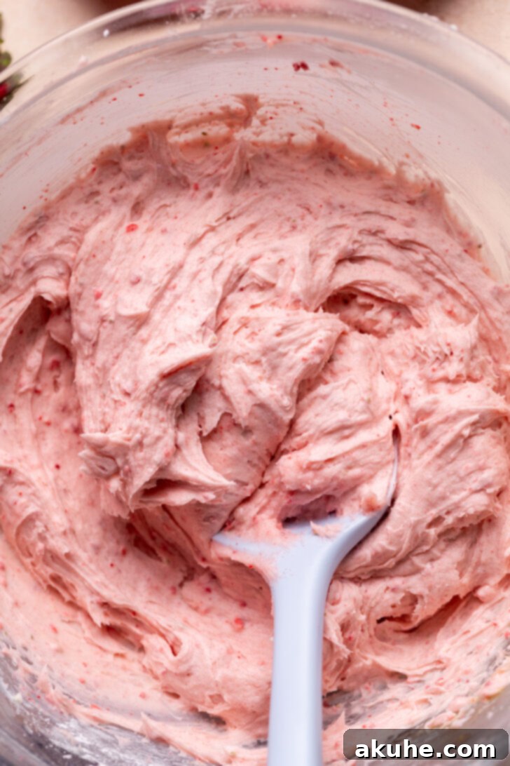 Perfect Fresh Strawberry Cake 7 Smooth and creamy strawberry cream cheese frosting prepared in a glass bowl, ready to be spread.