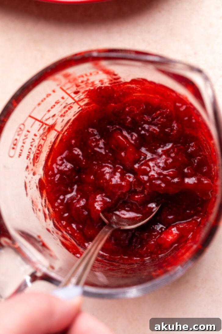 Perfect Fresh Strawberry Cake 8 Homemade strawberry jam, showcasing its rich red color and thick consistency, cooling in a glass bowl.