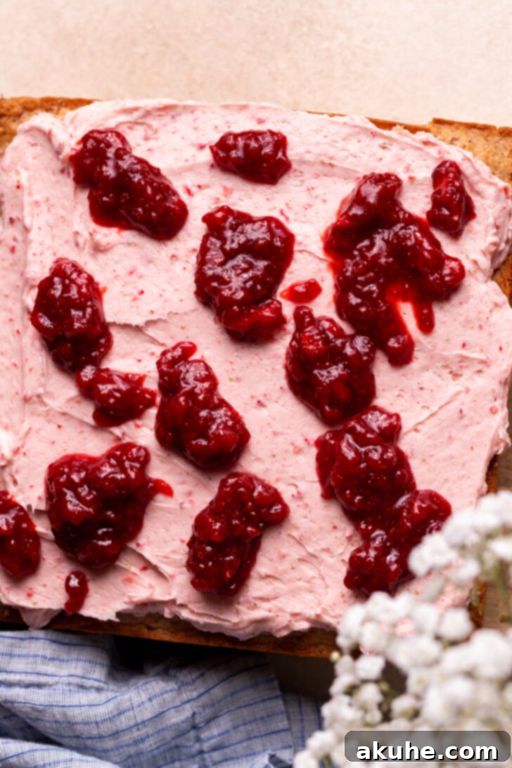 Perfect Fresh Strawberry Cake 10 Dollops of strawberry jam carefully placed on top of a frosted strawberry cake, ready for swirling.