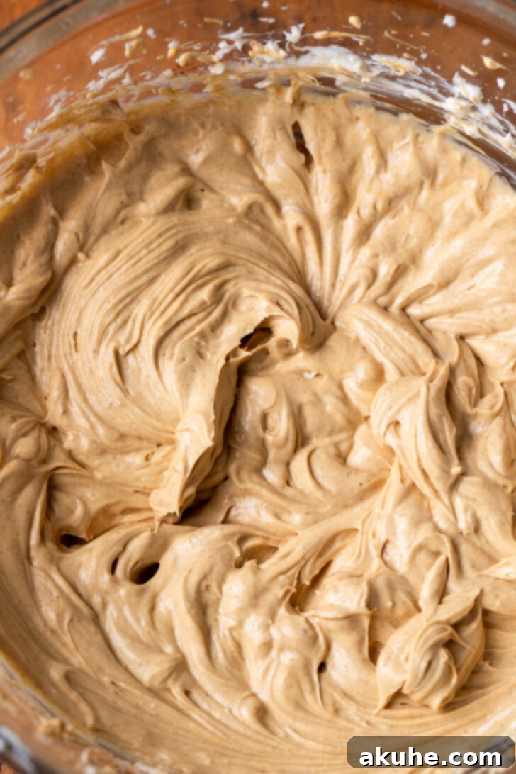 Close-up of cream cheese mixture in a bowl, showing a smooth texture.