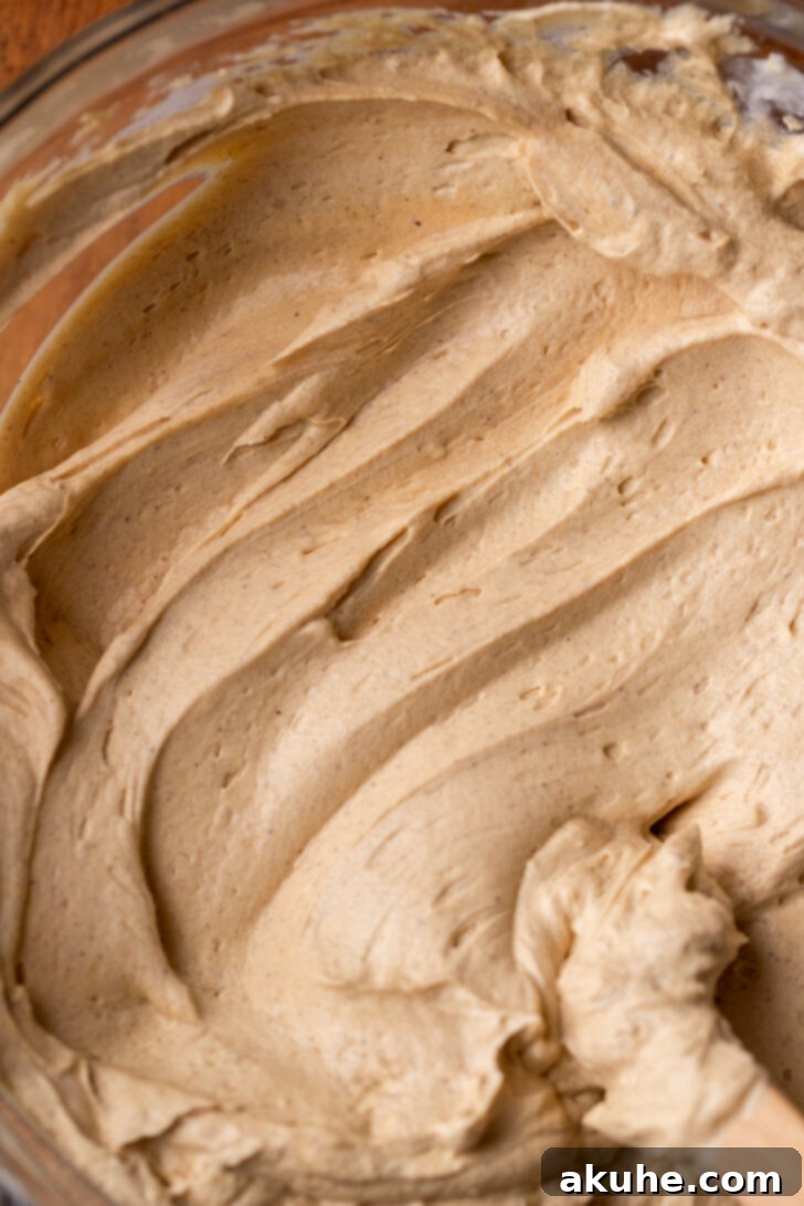 Fluffy, light gingerbread cheesecake batter in a mixing bowl after whipped cream has been folded in.