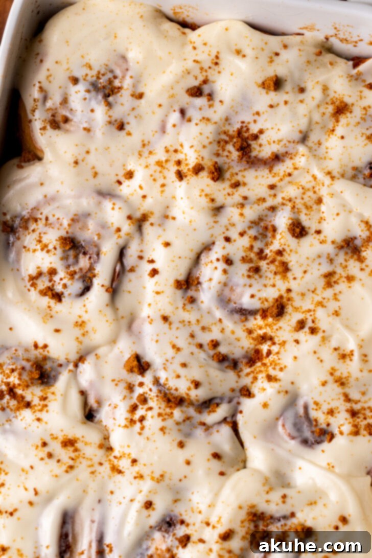 Festive Eggnog Swirls 9 Top view of iced eggnog cinnamon rolls, glistening with cream cheese frosting.