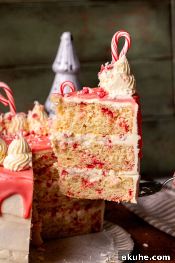 A slice of white chocolate peppermint cake being carefully lifted from the main cake, ready to be served.