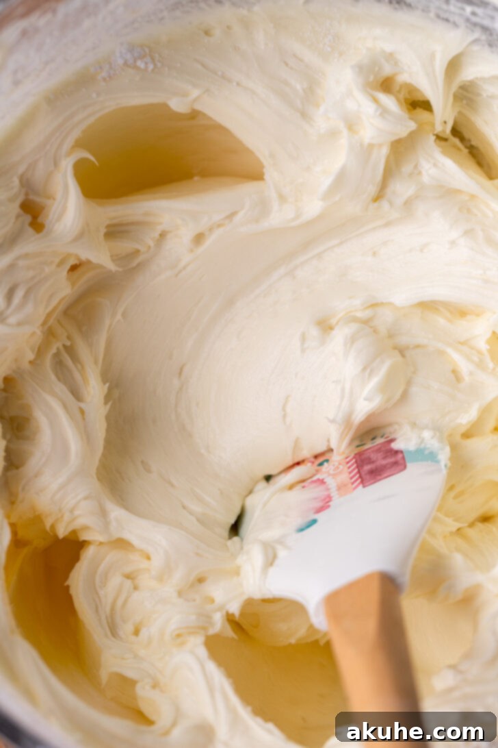 Creamy white chocolate cream cheese frosting in a mixing bowl, smooth and ready for application.