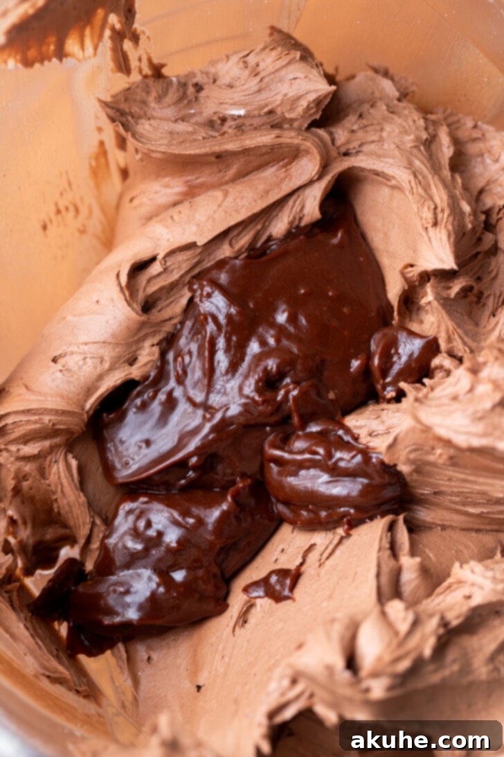 Hot chocolate fudge sauce being added to frosting.