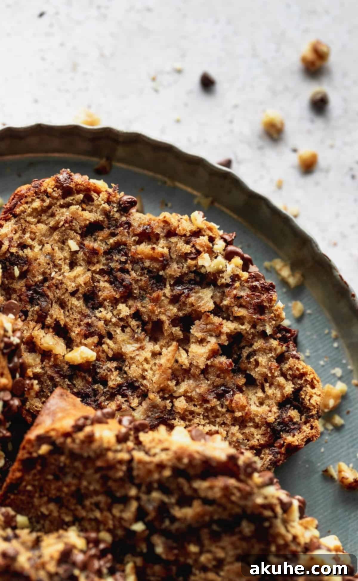 Ultimate Chocolate Walnut Banana Bread 7 A close-up of a single slice of walnut chocolate chip banana bread, highlighting its moist texture and visible mix-ins.