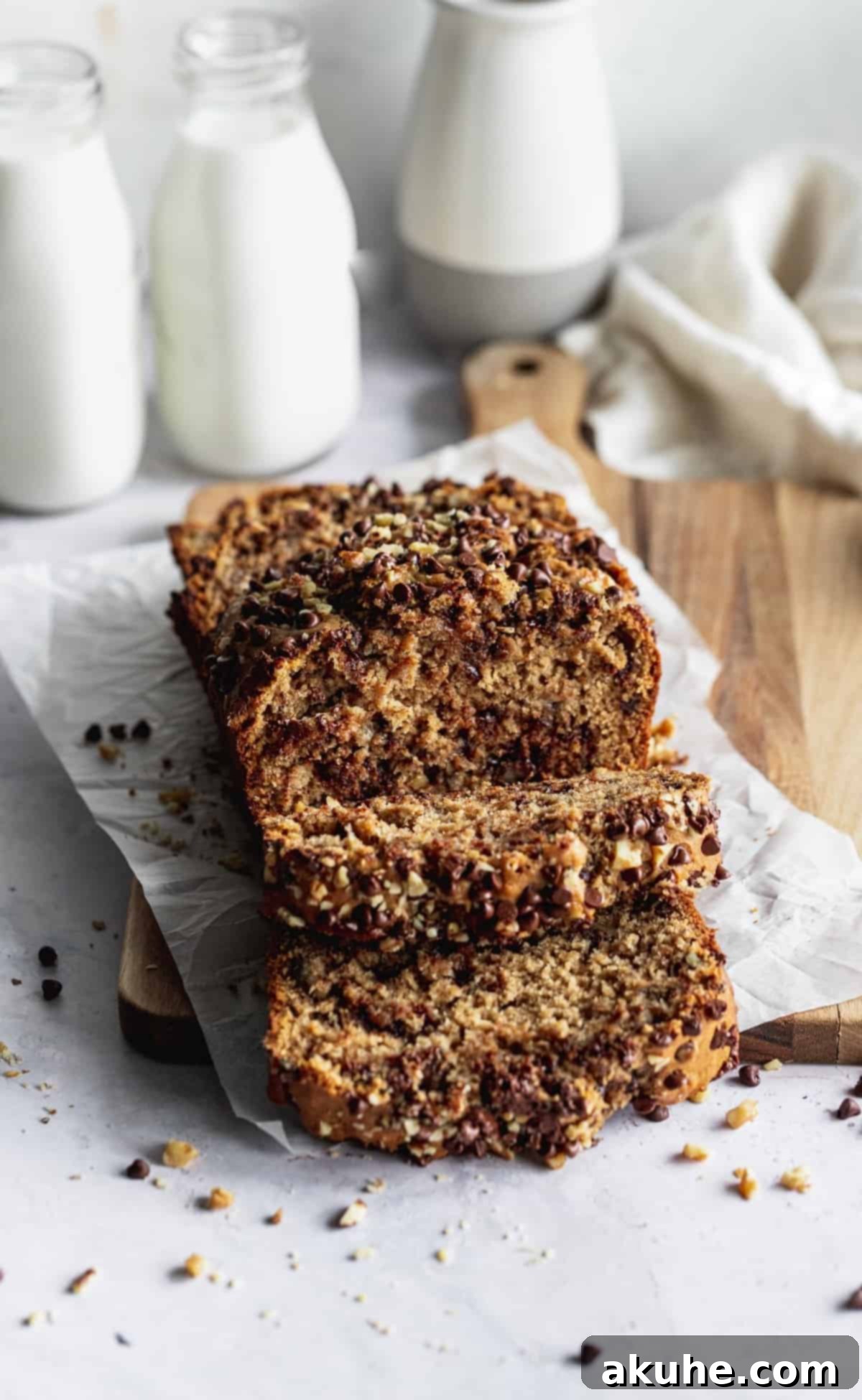 Ultimate Chocolate Walnut Banana Bread 8 Multiple slices of banana bread arranged artfully on a wooden cutting board, ready for serving or sharing.
