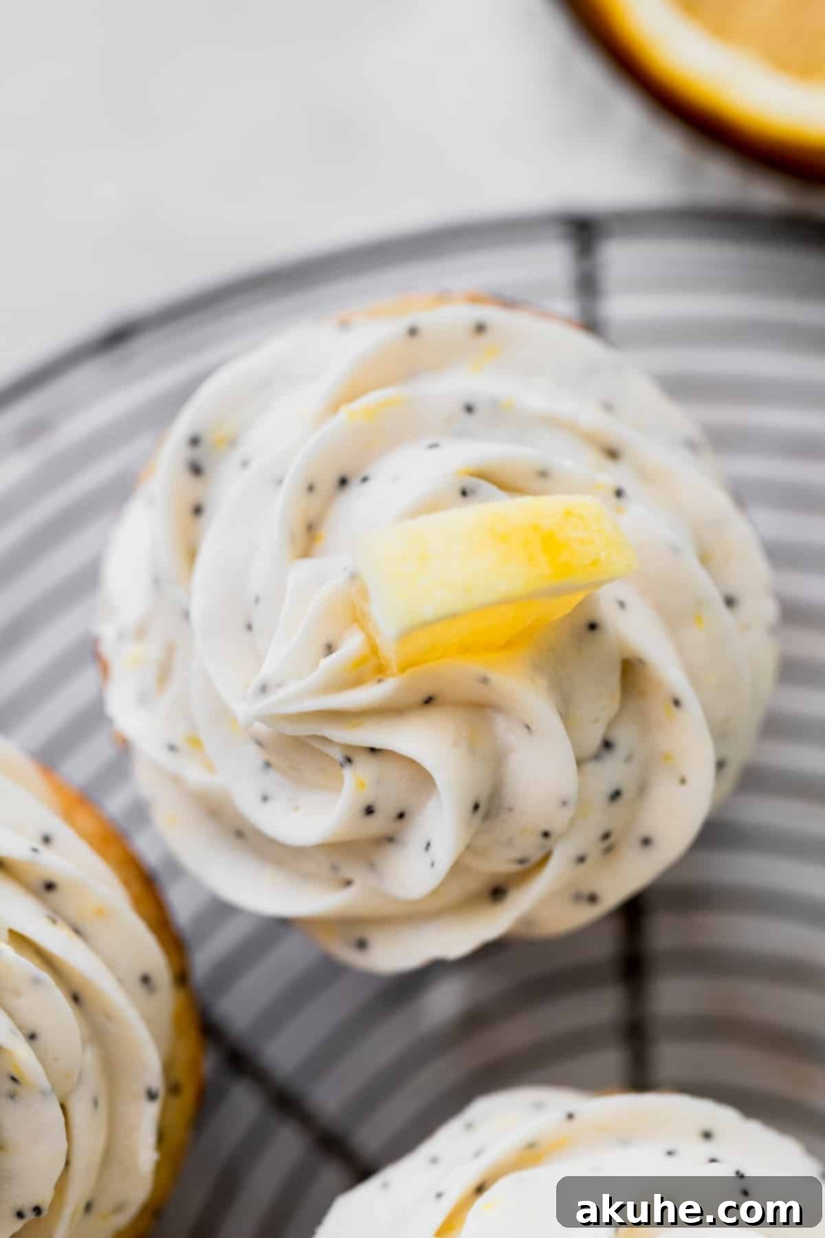 Sunshine Lemon Poppy Seed Cupcakes 10 An overhead view of frosted lemon poppy seed cupcakes, garnished with small lemon wedges.