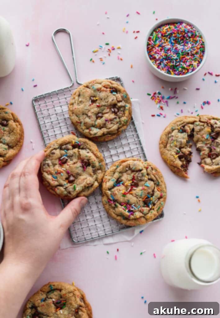 Sprinkle chocolate chip cookies cooling on a wire rack.