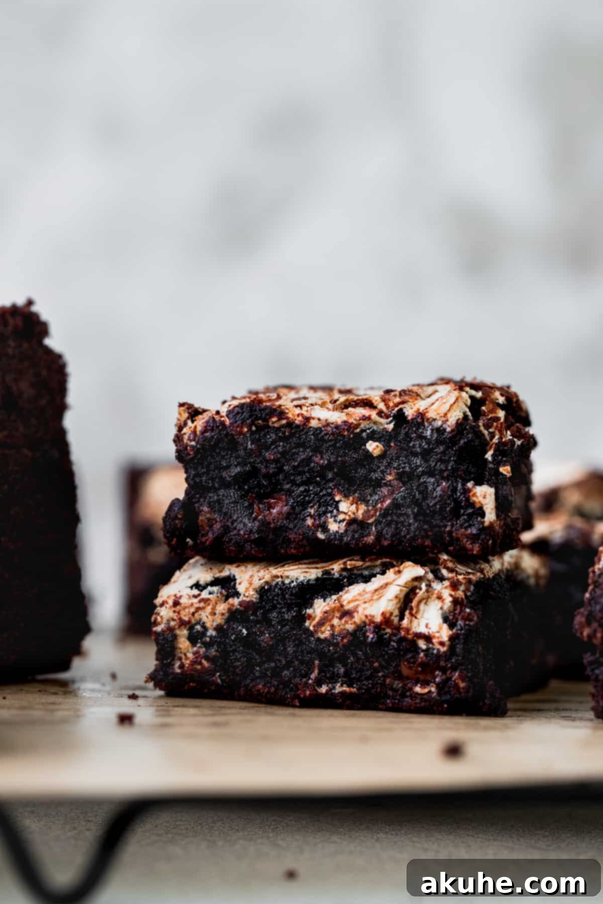 Decadent Marshmallow Brownies 11 A stack of two fudgy marshmallow swirl brownies resting on a wire cooling rack.