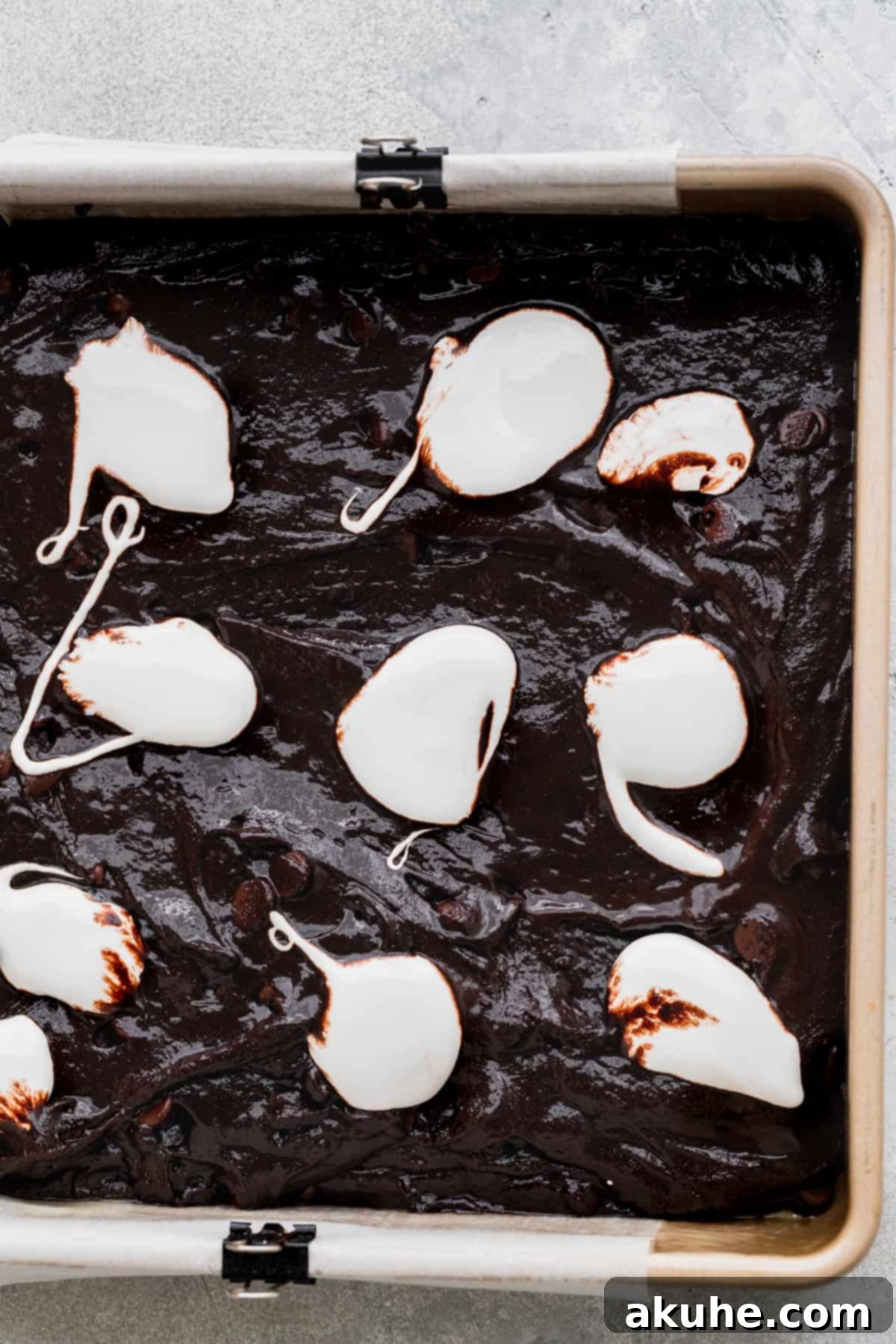 Decadent Marshmallow Brownies 7 Dollops of marshmallow fluff arranged on top of the brownie batter, ready for swirling.