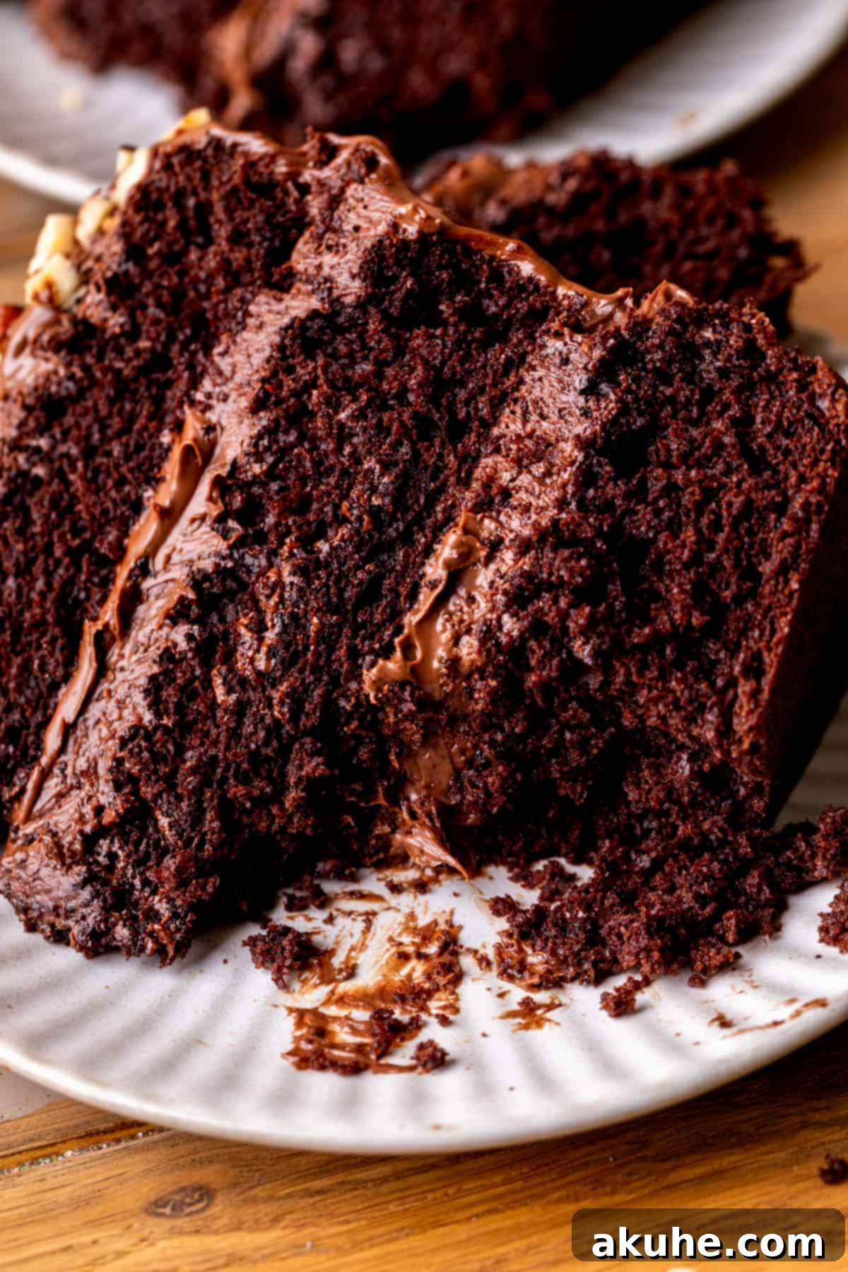 A close-up of a slice of Nutella cake with a bite taken out, showing the gooey filling and moist layers.