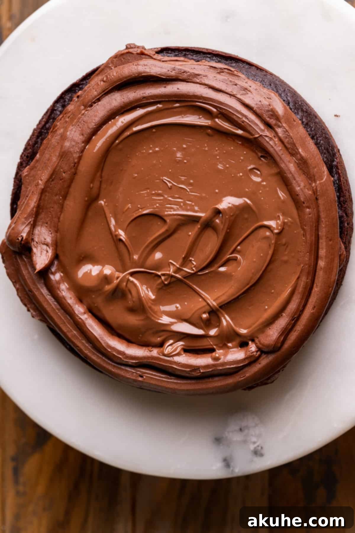 Melted Nutella filling poured onto a cake layer with a frosting dam.