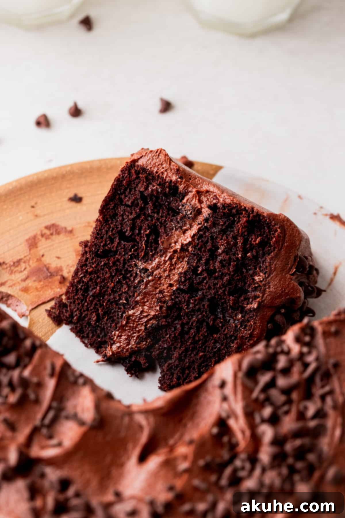 Close-up of a chocolate cake slice on a pristine white platter.