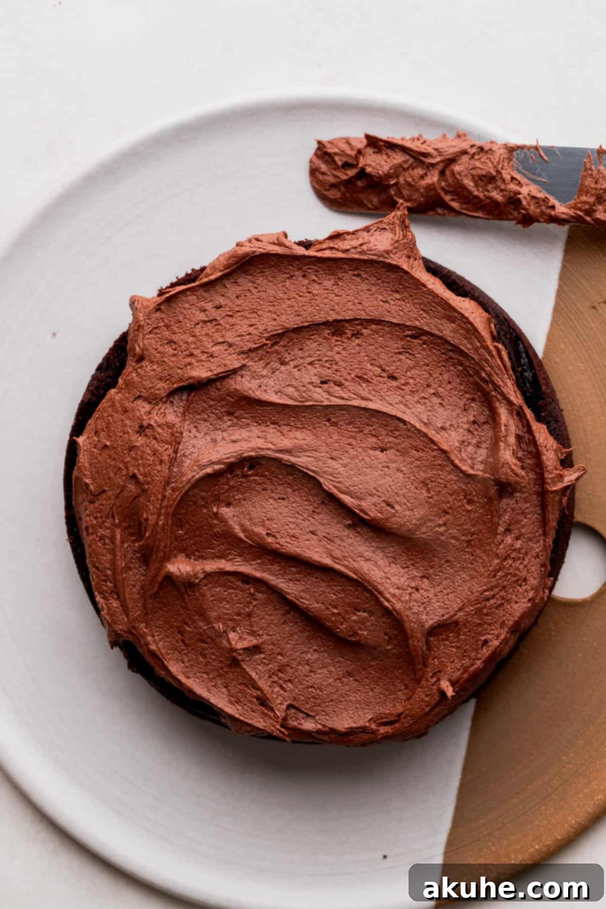 Thick layer of chocolate frosting spread on top of the cake.