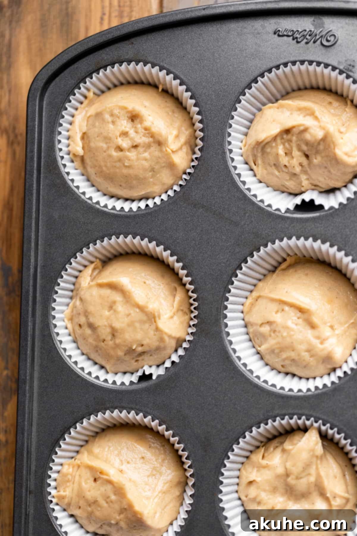 Maple Bacon Bliss Cupcakes 6 Unbaked maple cupcake batter neatly scooped into a muffin pan with paper liners.