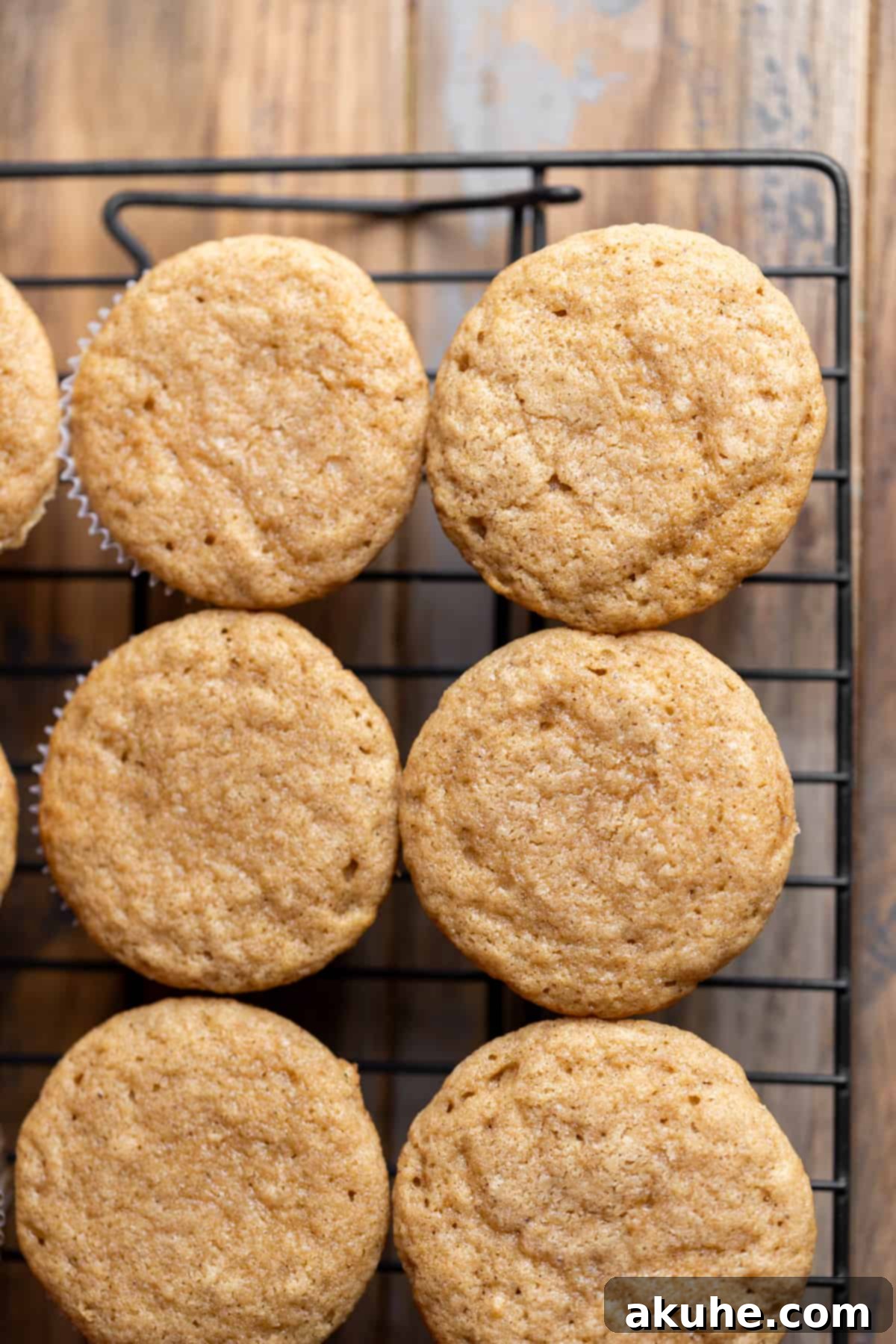 Maple Bacon Bliss Cupcakes 7 Freshly baked maple cupcakes cooling on a wire rack, ready for frosting.