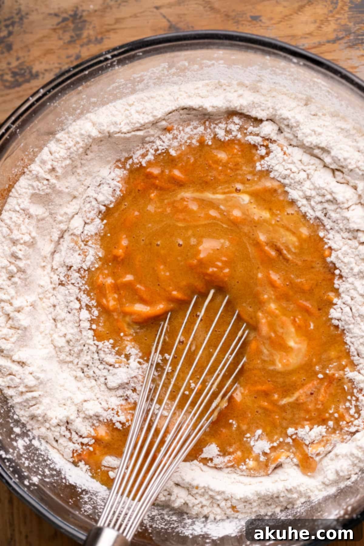 Heavenly Carrot Cake 4 Wet ingredients beautifully poured over the carefully measured dry ingredients, ready for gentle mixing into a carrot cake batter.
