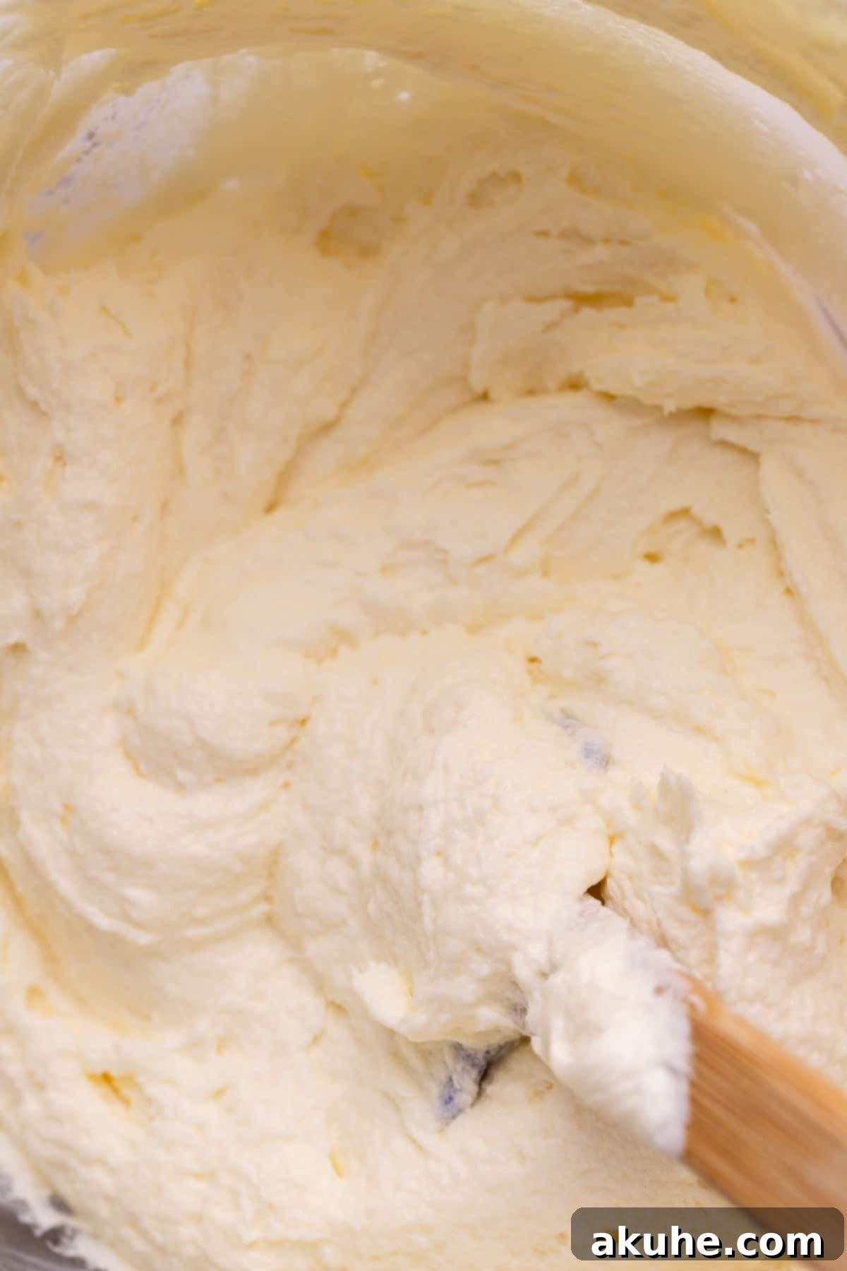 Heavenly Carrot Cake 7 A bowl of rich, creamy cream cheese frosting, perfectly smooth and ready to be spread onto a delicious carrot cake.