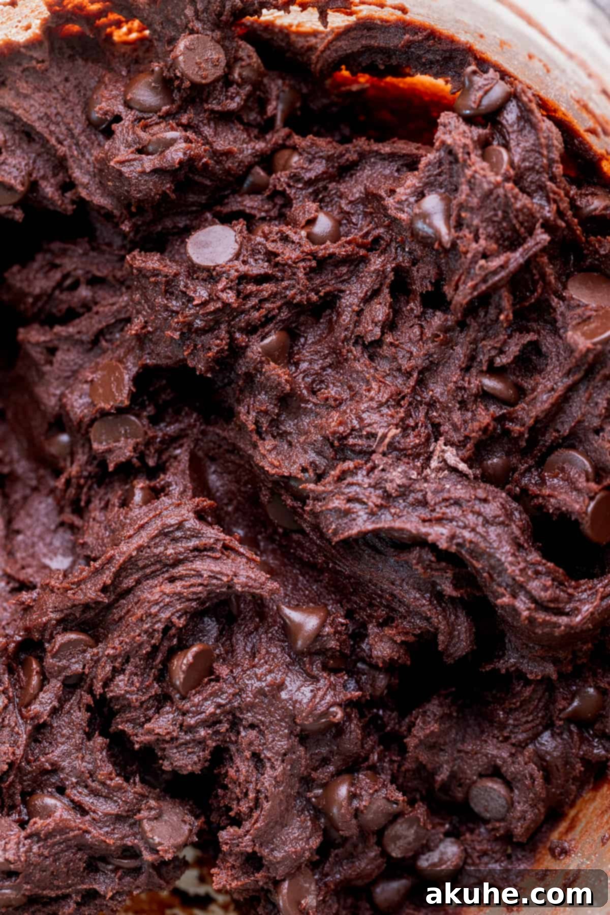 Chocolate cookie dough in a glass bowl, after mixing.