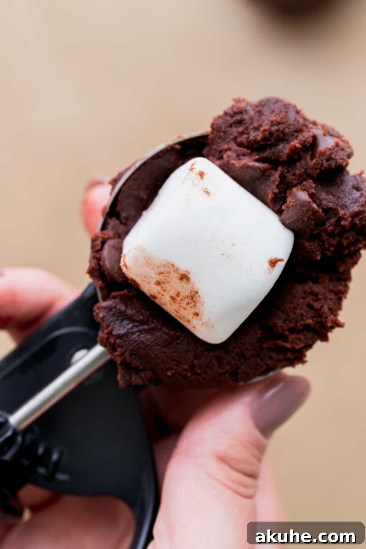 Marshmallow placed on top of a scoop of cookie dough, ready to be enclosed.