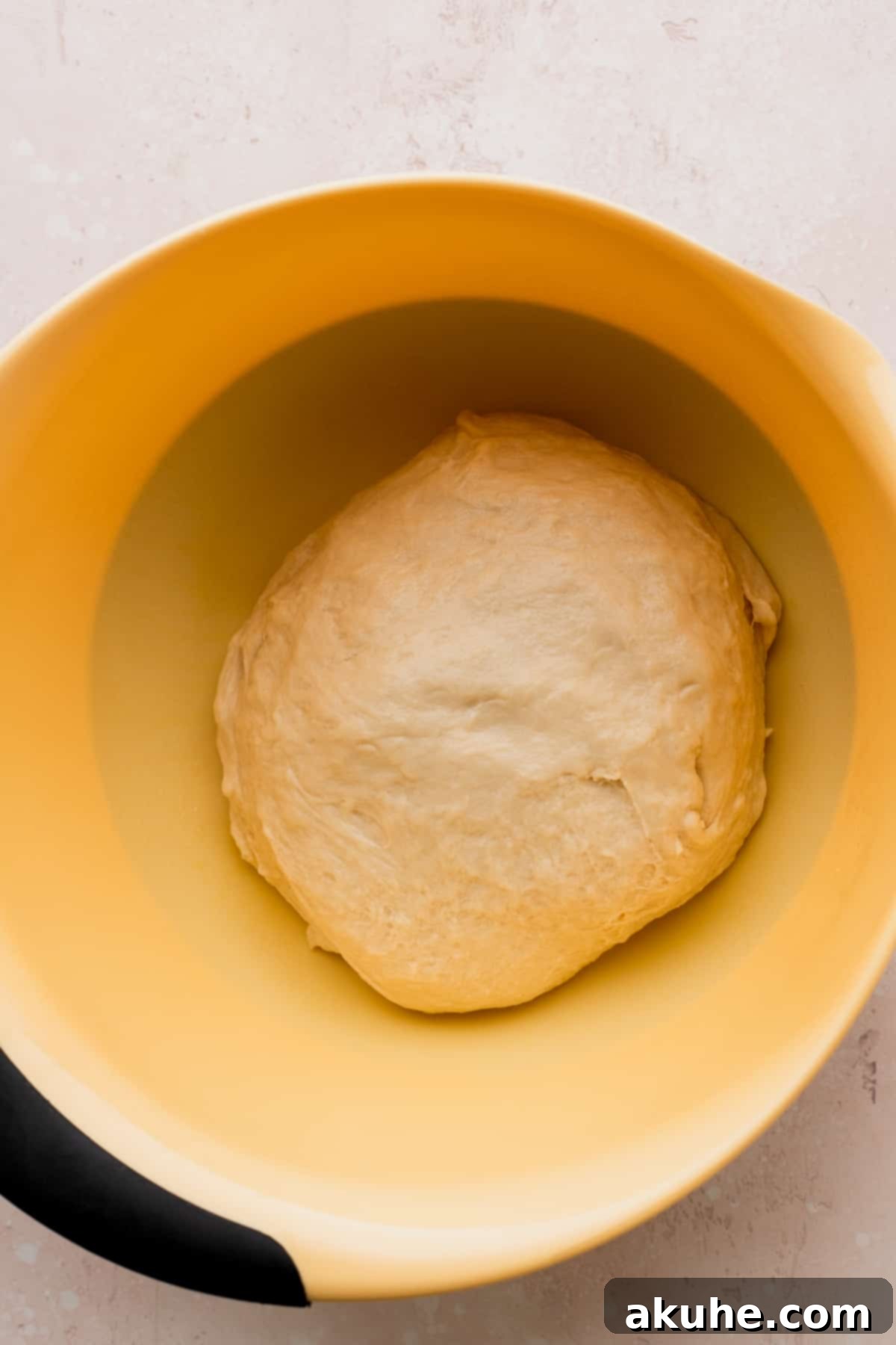 Colossal Cinnamon Buns 6 Dough before rising in a yellow bowl.