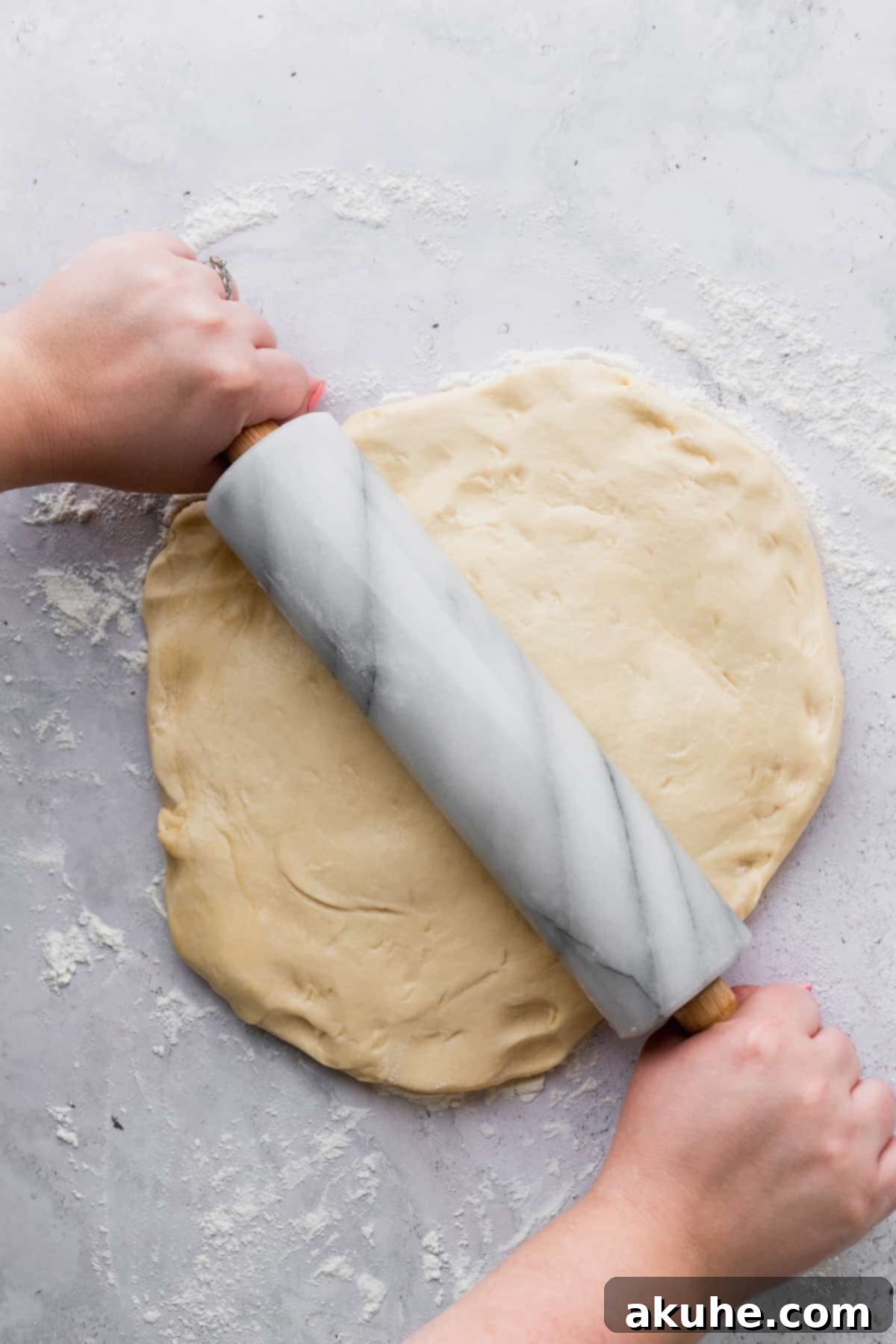 Colossal Cinnamon Buns 8 Rolling out the dough using a rolling pin.