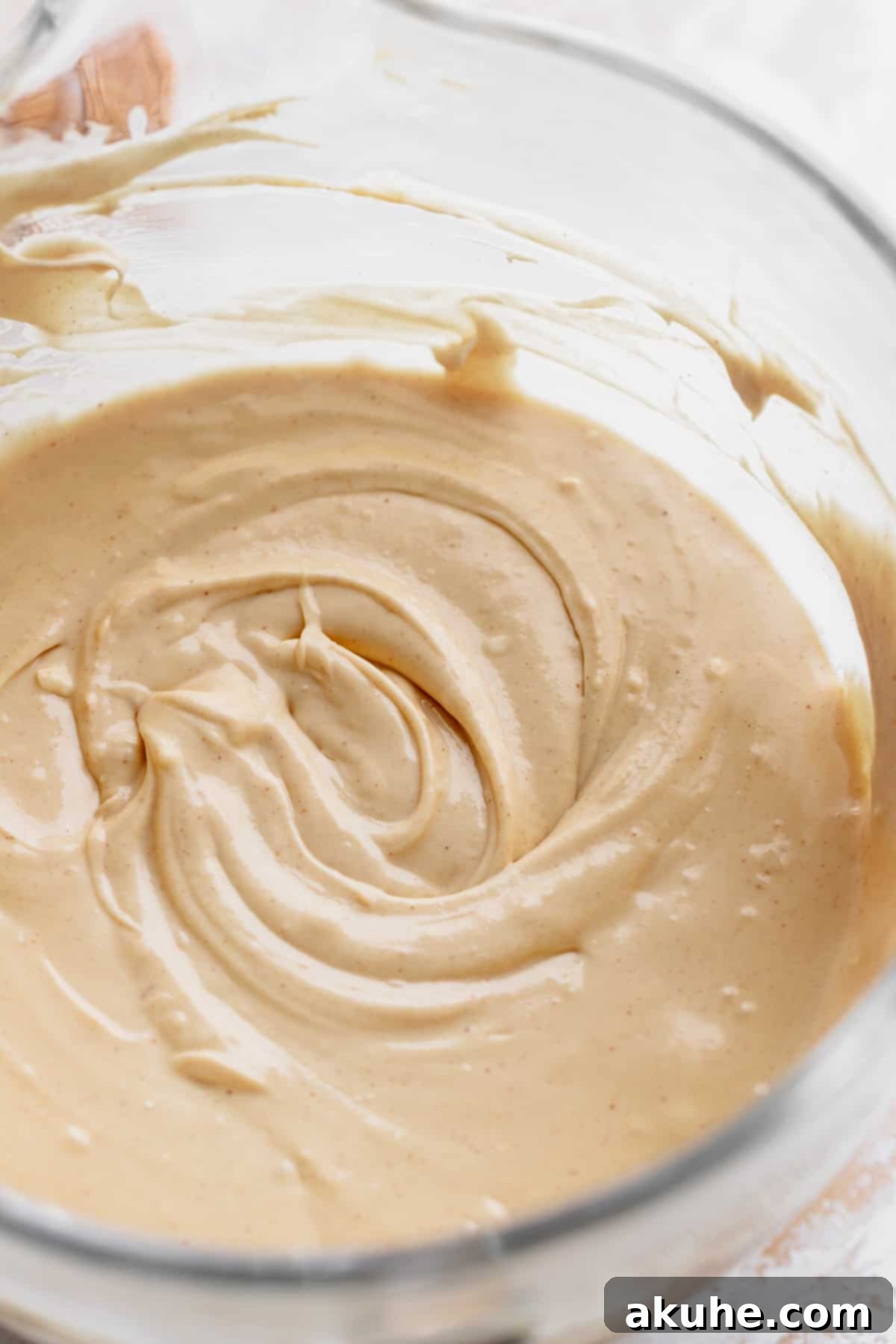 Smooth peanut butter cheesecake batter in a glass mixing bowl.