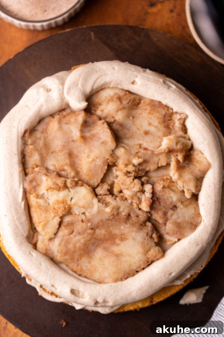 Golden Cinnamon Swirl Cake 12 A flattened disc of snickerdoodle cookie dough carefully placed on top of a frosted cake layer.