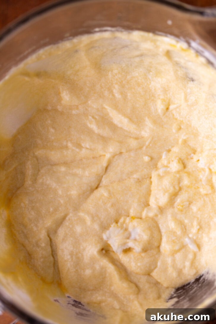 Golden Cinnamon Swirl Cake 4 Wet ingredients (oil, butter, sugar) being beaten in a stand mixer bowl until light and fluffy.