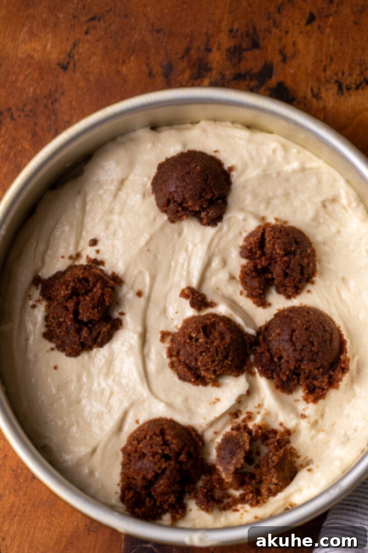 Golden Cinnamon Swirl Cake 6 Cake batter with dollops of cinnamon filling evenly distributed in a round cake pan.