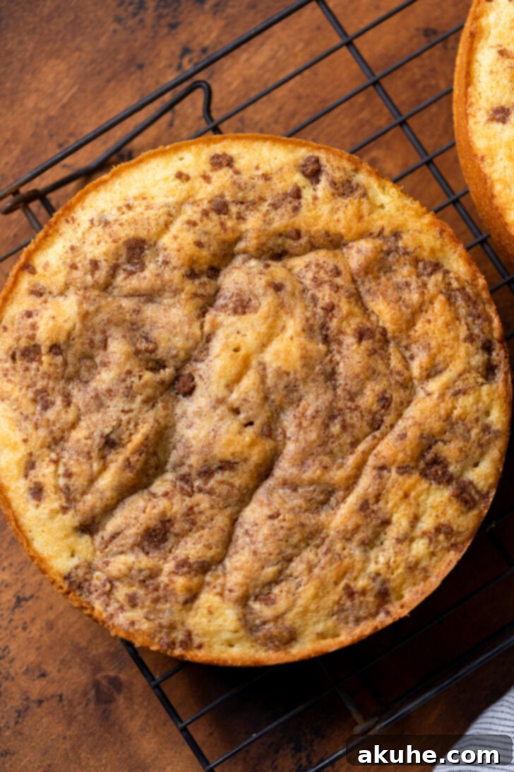 Golden Cinnamon Swirl Cake 8 A freshly baked cake layer cooling on a wire rack after being removed from the pan.