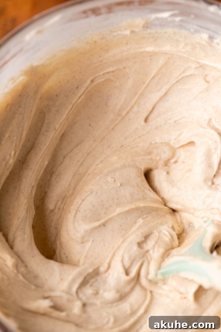 Golden Cinnamon Swirl Cake 10 Smooth cinnamon cream cheese frosting in a mixing bowl, perfectly whipped and ready.