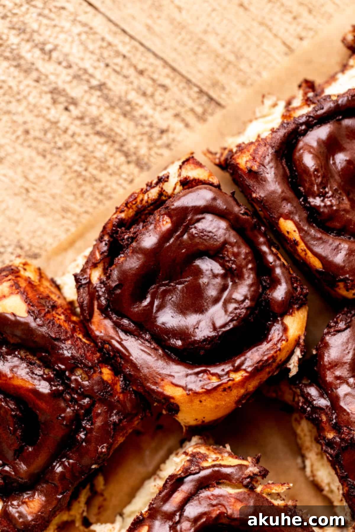 Chocolate Cinnamon Rolls 3 Freshly baked chocolate cinnamon rolls arranged neatly on parchment paper.