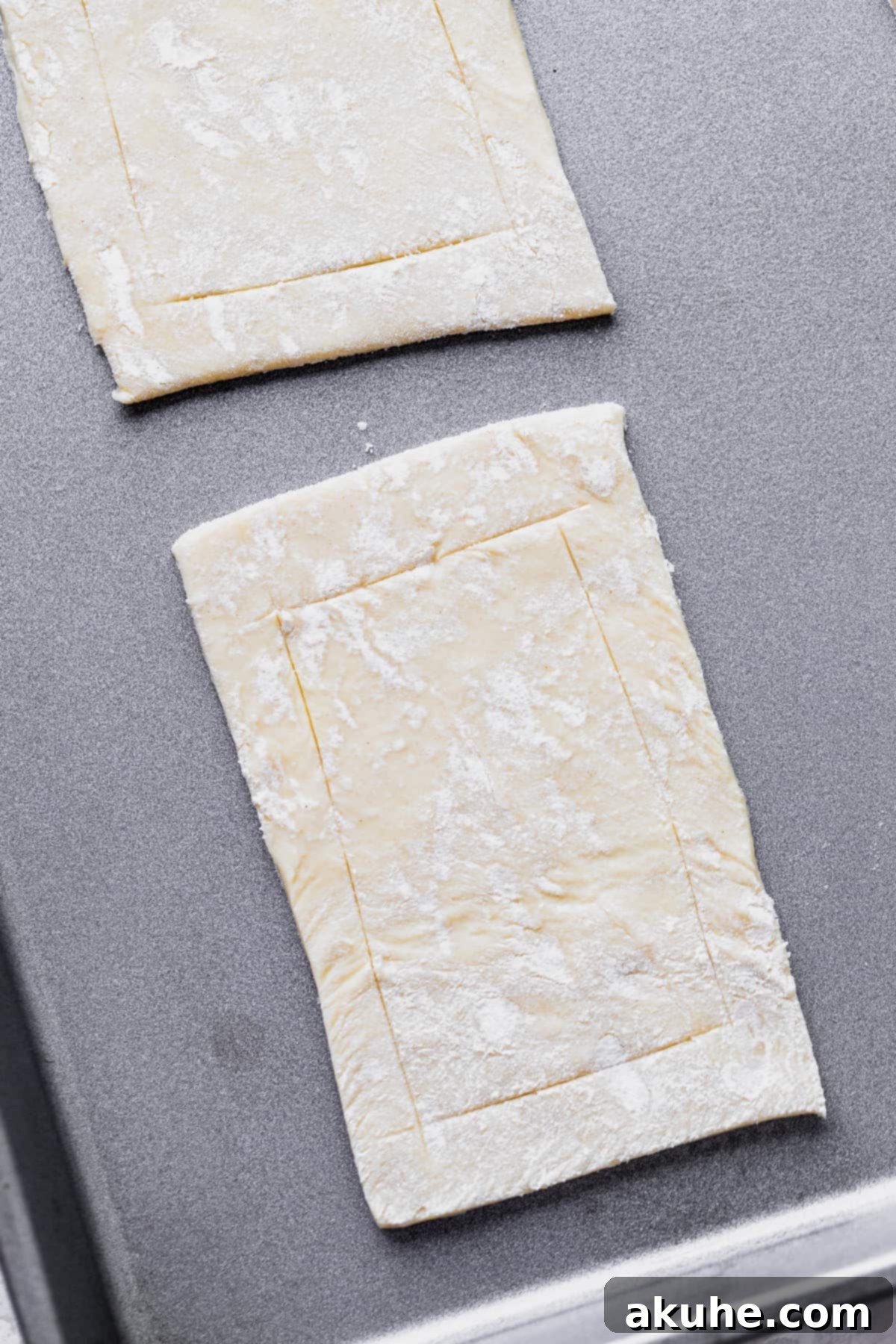 A sheet of raw puff pastry on a baking sheet, ready for cutting.