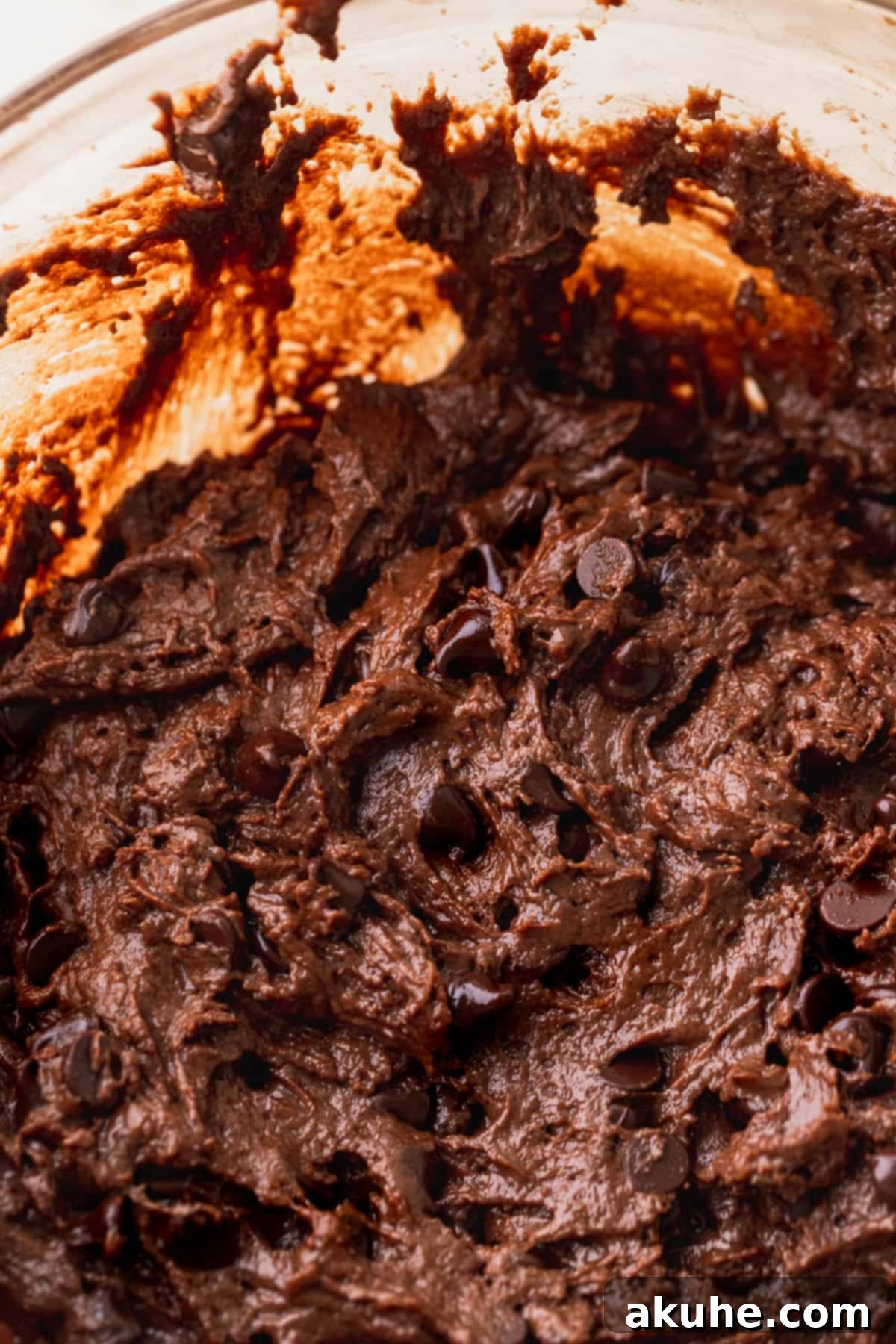 Decadent Triple Chocolate Muffins 5 Close up of chocolate muffin batter in a glass bowl.