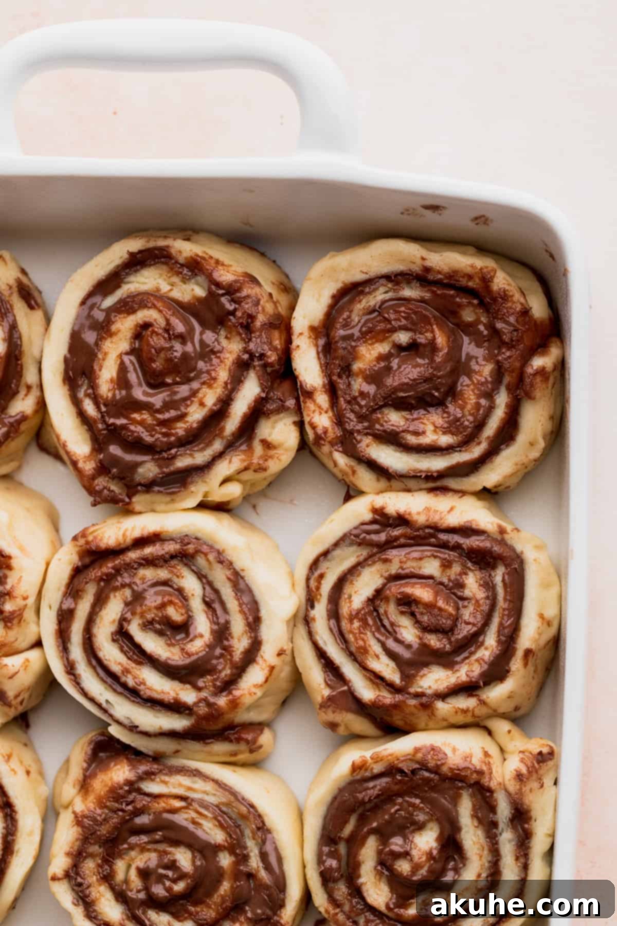 Raw, unbaked rolls arranged in a baking pan, ready for their second rise.