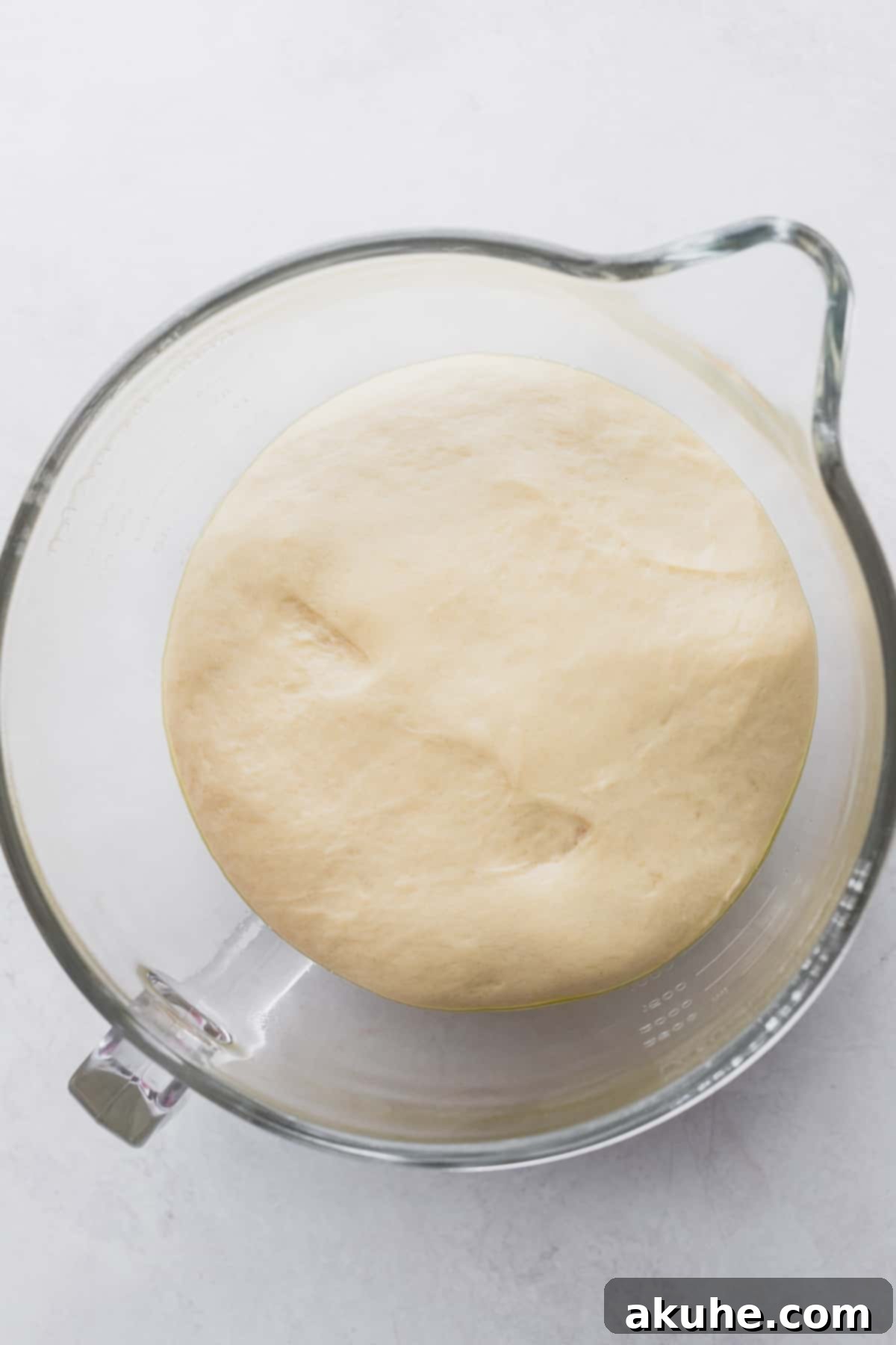Perfectly risen dough in a glass bowl, doubled in size.