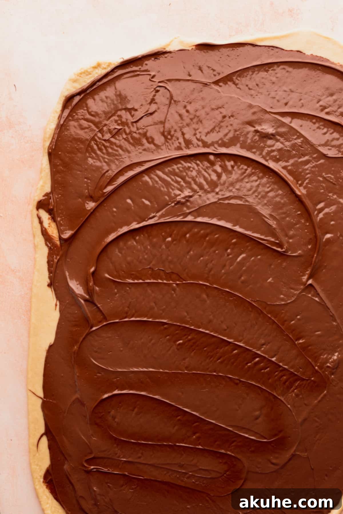 Nutella spread smoothly over the rolled-out dough.