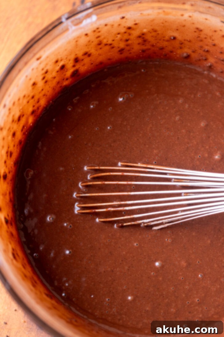 Smooth chocolate cake batter in a mixing bowl, ready to be poured into the pan.