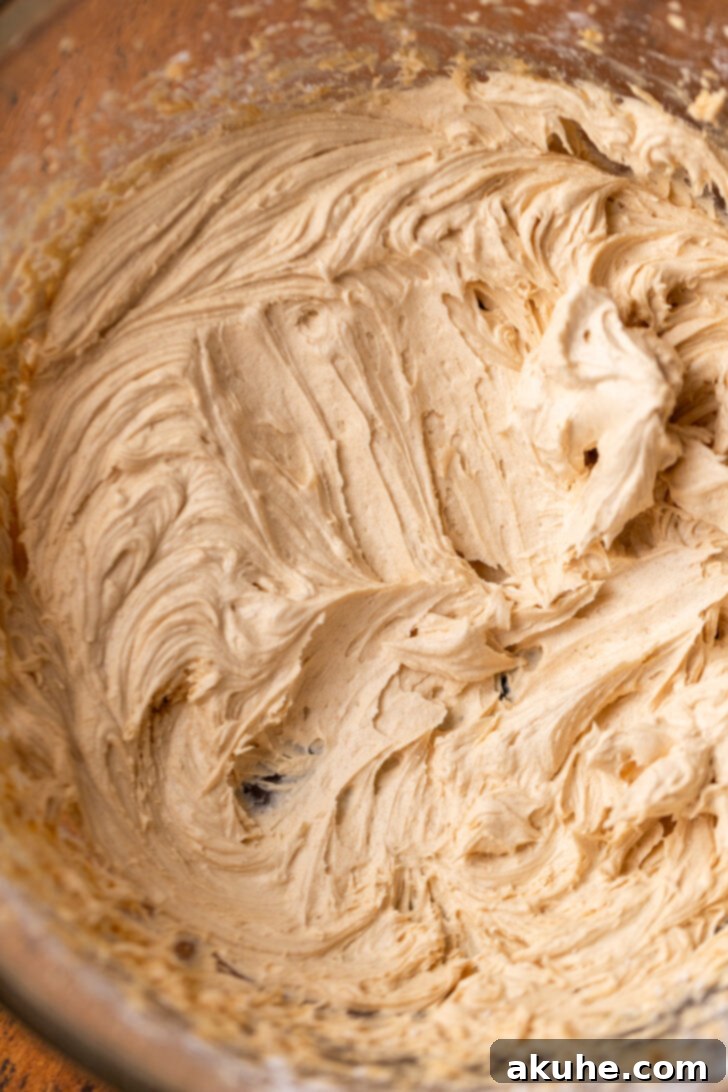 Creamy peanut butter frosting in a bowl, showing its smooth and fluffy texture.