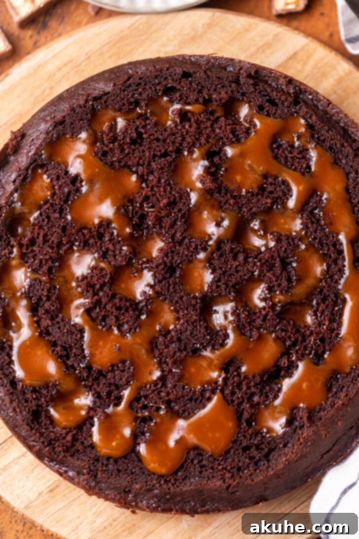 A chocolate cake with holes poked into its surface, ready to be filled with caramel.
