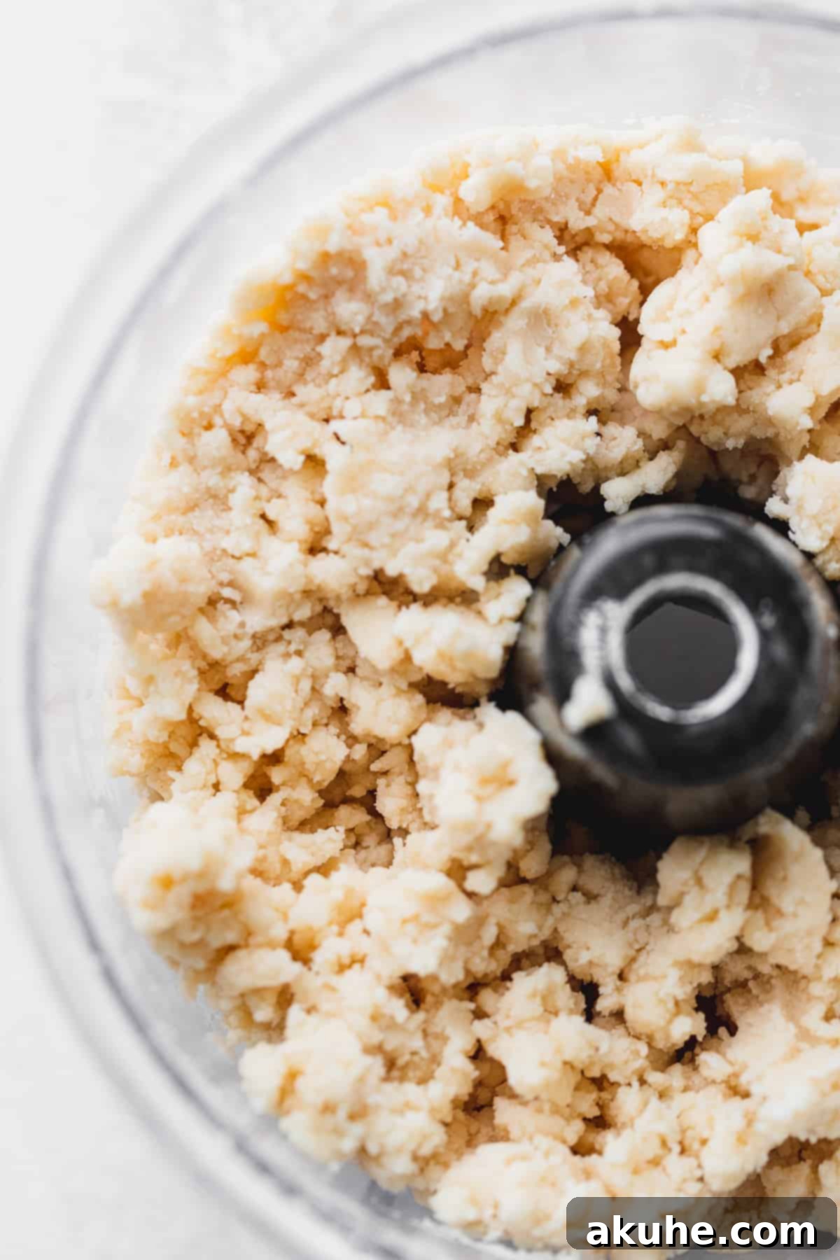 Blueberry Pie Bites 6 Step-by-step image showing the pie dough after ice water has been added, starting to clump together into a cohesive dough.