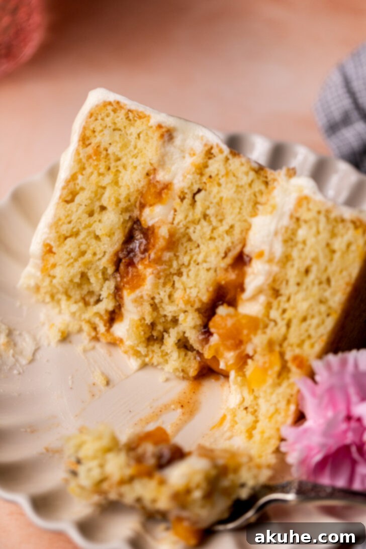 A slice of Peach Cobbler Cake with a bite missing, tempting anyone who sees it.