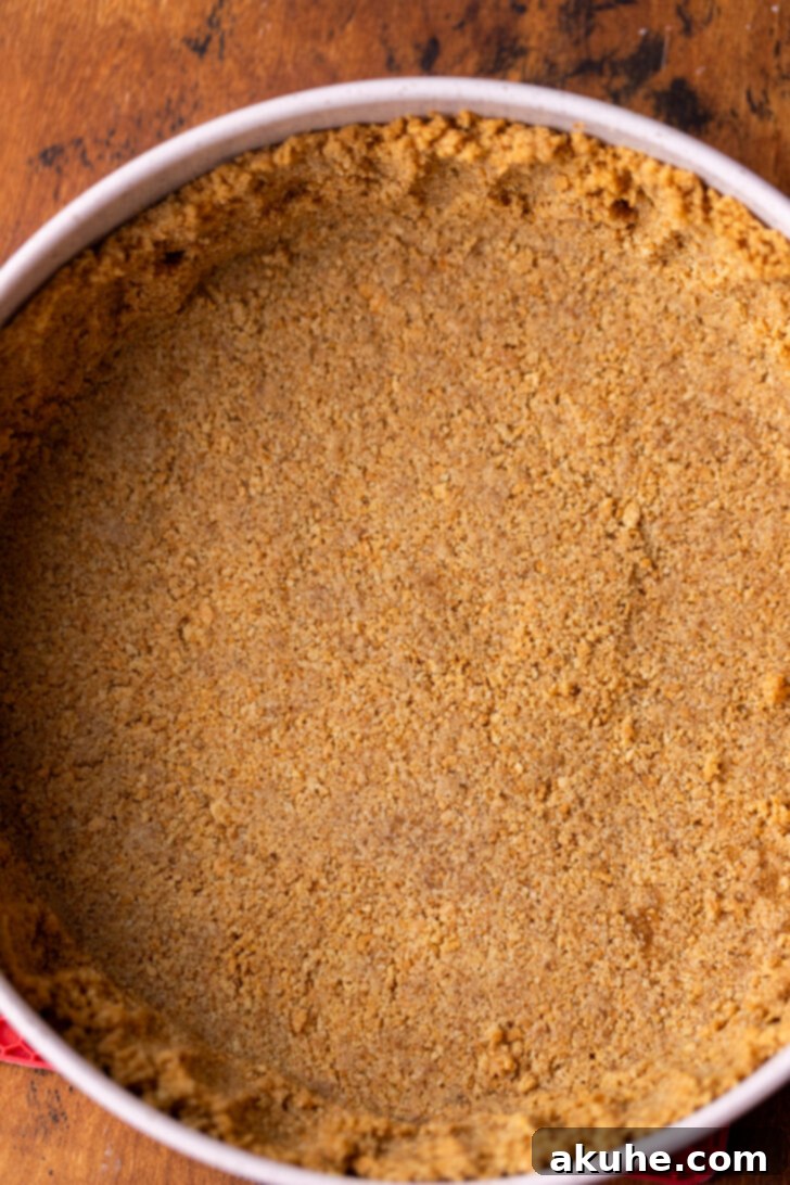 Velvet Caramel Indulgence 6 A perfectly pressed graham cracker crust lining the bottom and sides of a springform pan, prepped for baking.