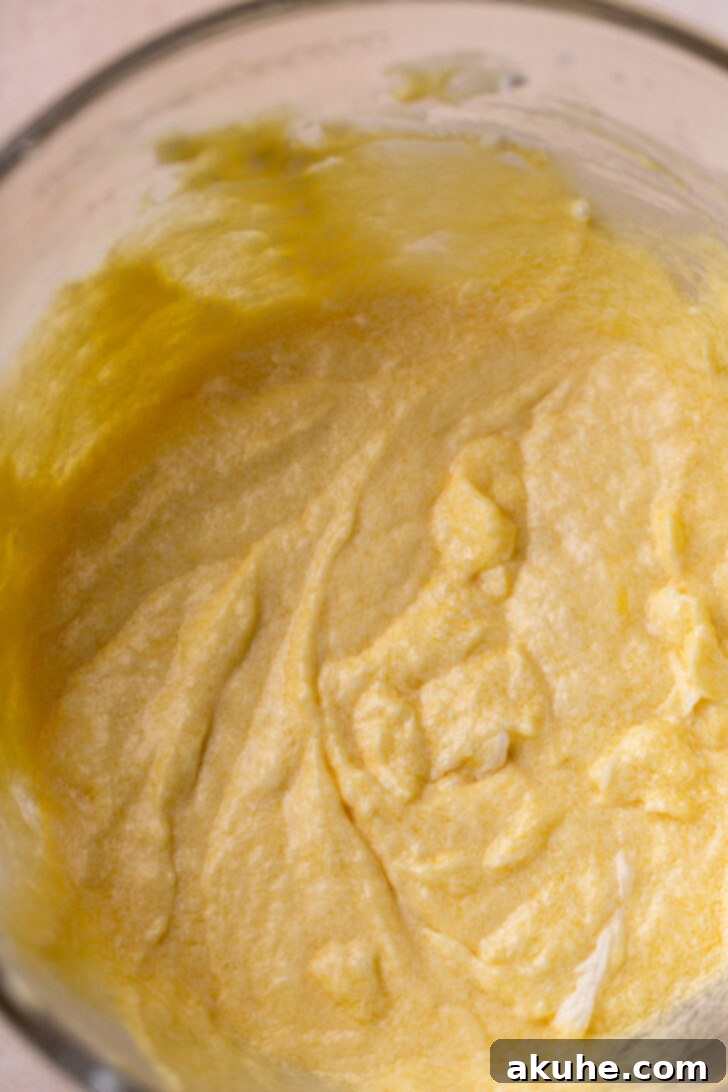 Classic Yellow Cake 4 A mixing bowl filled with wet ingredients, visibly yellow from the abundant egg yolks, ready to be incorporated into the cake batter.