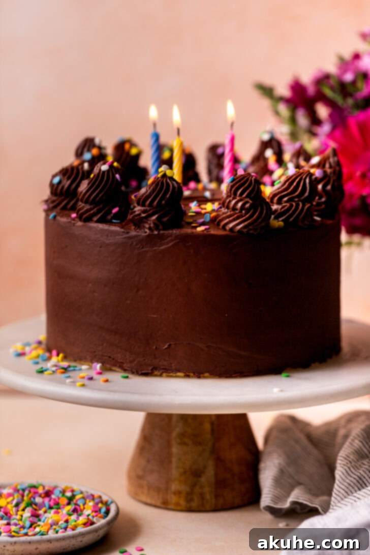 Classic Yellow Cake 10 A fully decorated three-layer homemade yellow cake, presented on a elegant cake stand, ready to be served.