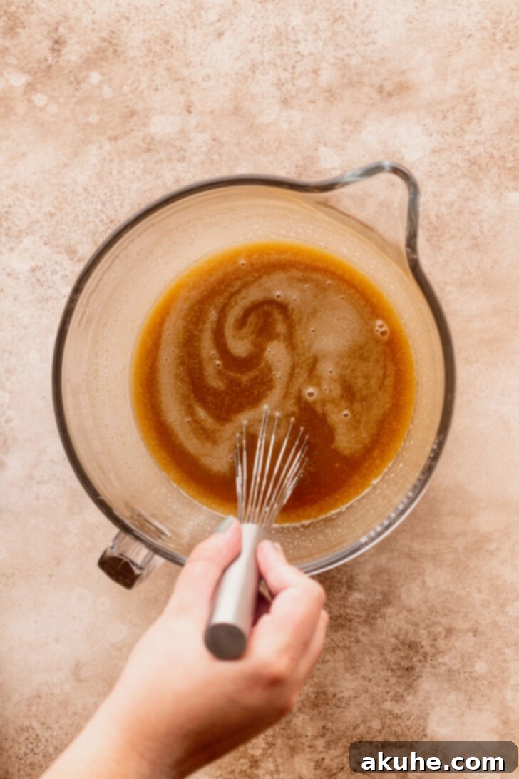 Spiced Apple Cider Donut Cake 4 Wet ingredients for the cake batter in a mixing bowl, ready to be combined.