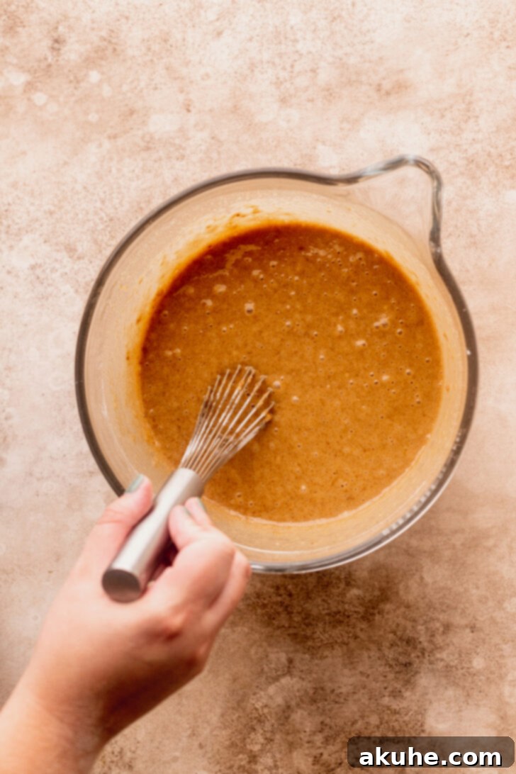 Spiced Apple Cider Donut Cake 5 The fully mixed, liquidy cake batter in a bowl, showing its smooth consistency.